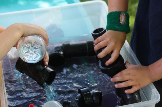 science activities: kids playing with water play activity bin