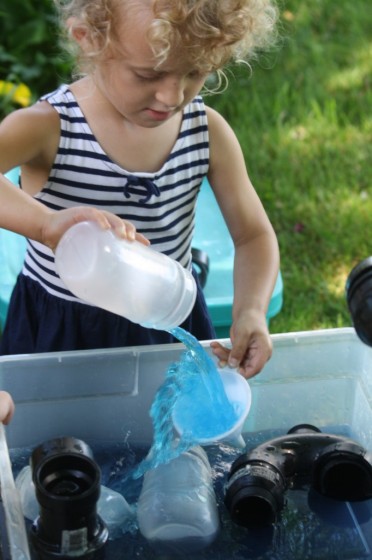 preschooler pouring water through funnels during science activities