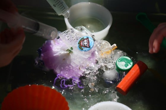 preschoolers squirting water on ice block