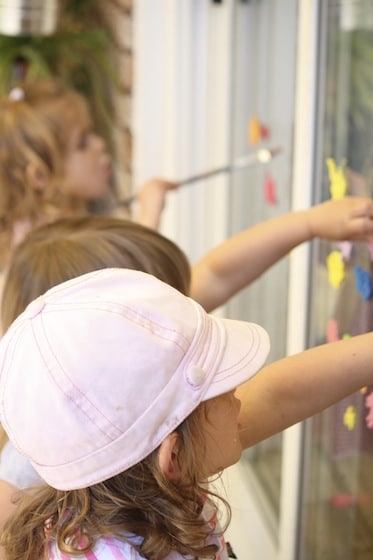 3 kids creating art on sliding glass door