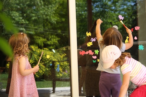 kids sticking foam shapes on window