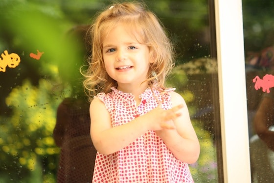 child standing in front of glass window