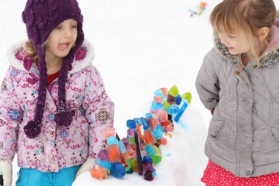 kids standing beside a coloured ice sculpture made with coloured ice cubes