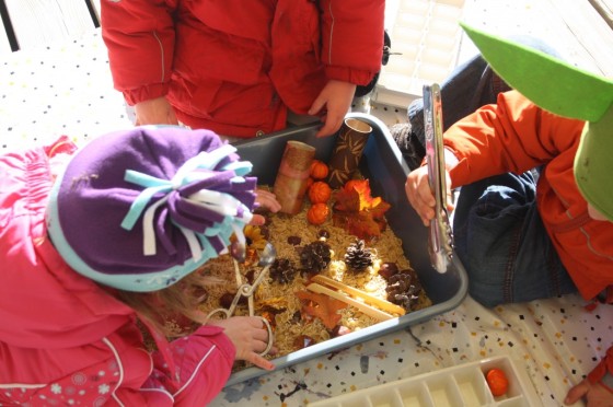 Preschoolers examining November sensory bin 