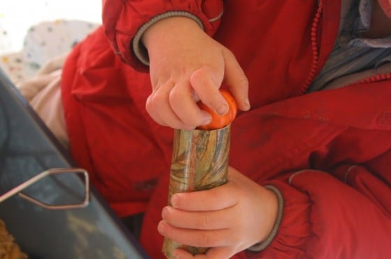 toddler transferring plastic pumpkin in to tube