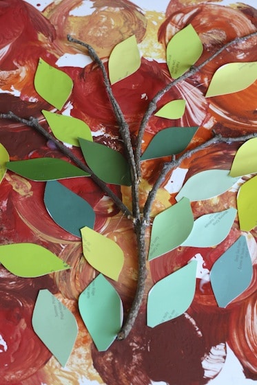 twigs and green leaf-shaped paint swatches on apple stamped background