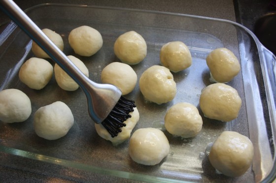 brushing homemade rolls with butter