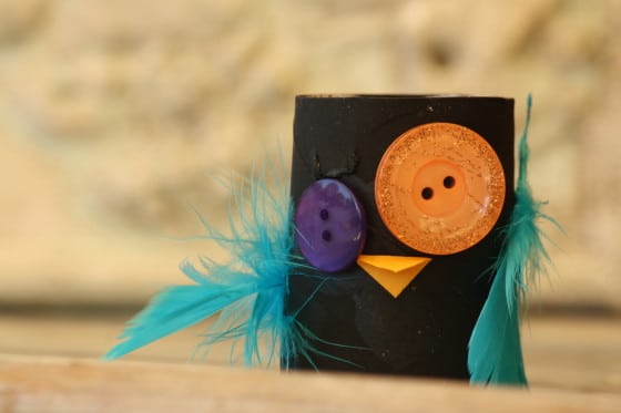 black toilet roll owl with orange and purple eyes 