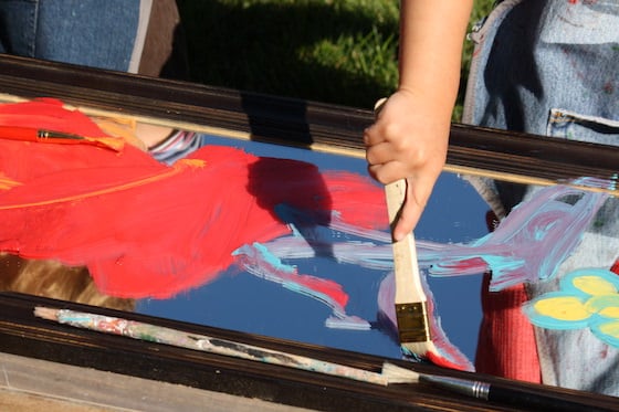 preschooler painting on a mirror with a brush