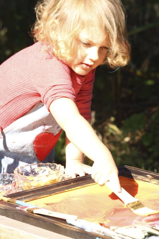 preschooler mirror painting with yellow paint