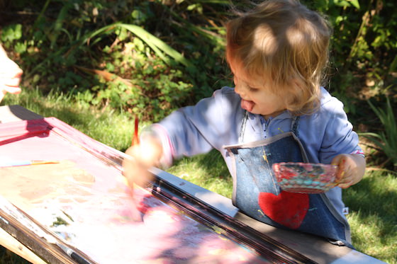 If you're looking for a fun backyard activity for the kids to do this summer, try this outdoor art idea! Painting on a mirror is calming and relaxing, and a wonderful way for kids to experiment with art in an outdoor setting.  We have a framed mirror that hangs in the dress-up area of our playroom.  I picked it up at a thrift shop a few years ago. It was so worth the couple of bucks I spent on it because it's so much more than just a dress-up mirror. We often take it off the wall and place it on a table and use it as a reflective table for art and sensory activities. One of the most popular activities among my preschoolers is the one I'm sharing with you today: painting on the mirror outdoors in the backyard.