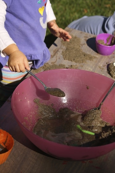 playing in a bowl of sand on a table