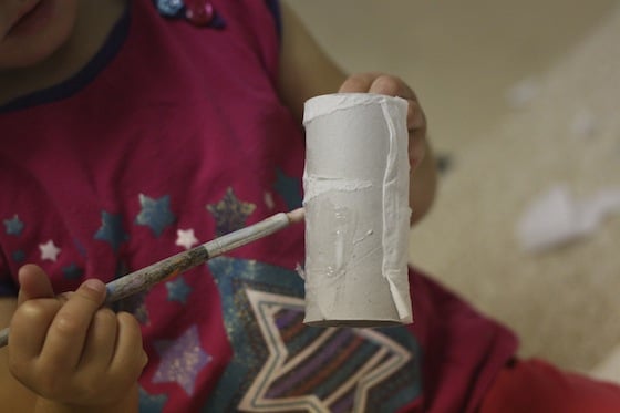 toddler painting glue on toilet roll