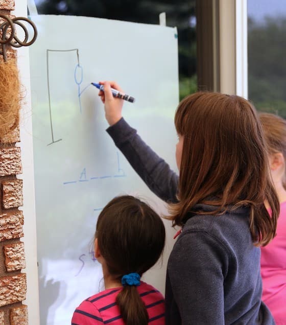 Kids playing hangman on sliding glass door