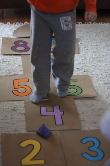 boy jumping on cardboard hopscotch