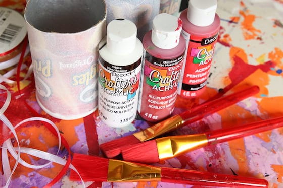 Pringles cans, red and white paint, ribbon, paintbrushes