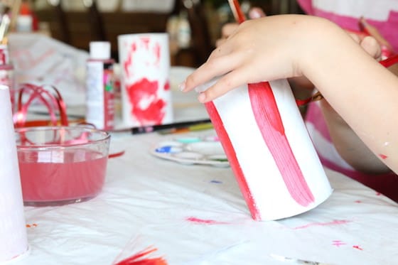 Kids painting pringles cans red and white