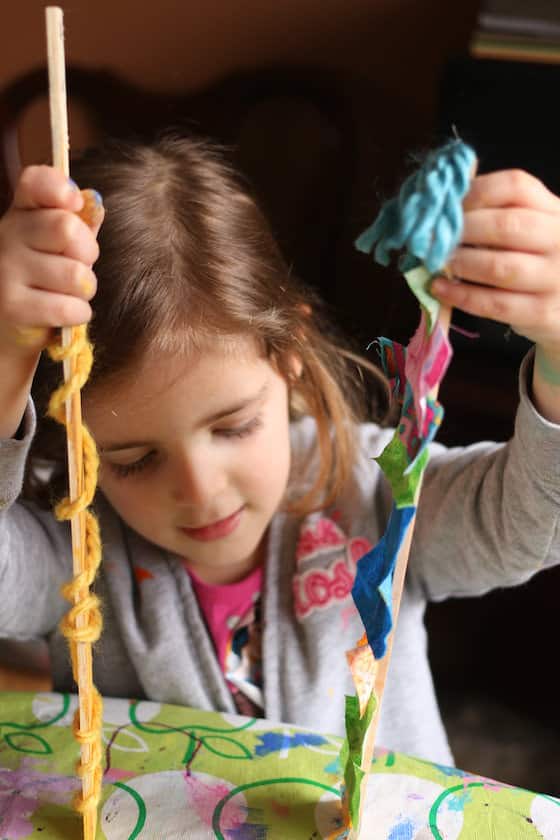 Preschooler playing with paint stick dolls