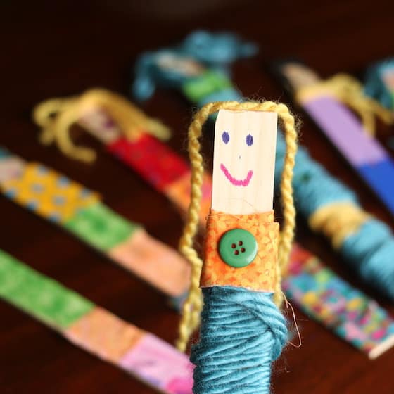 craft stick doll wrapped in fabric and yarn with button glued on