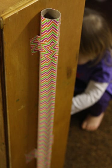 cardboard drop zone tube attached to side of cupboard