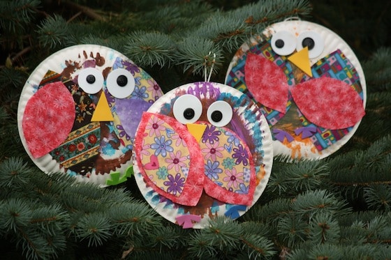 3 paper plate owls hanging in pine tree