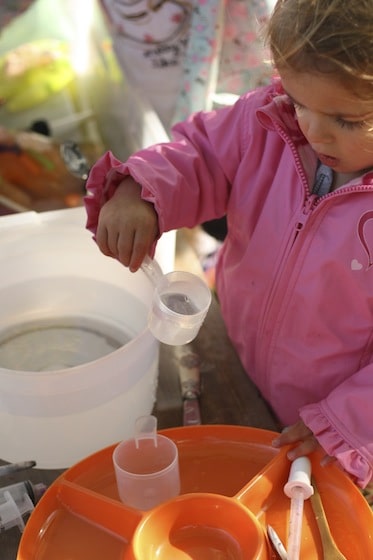 pouring water over ice in a kid's science experiment 