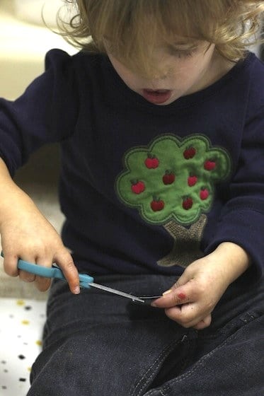 one year old learning to use scissors