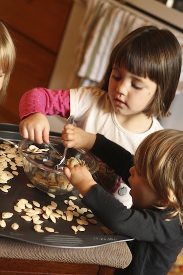 kids tossing pumpkin seeds in olive oil