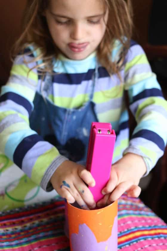 child stapling pringles cans together