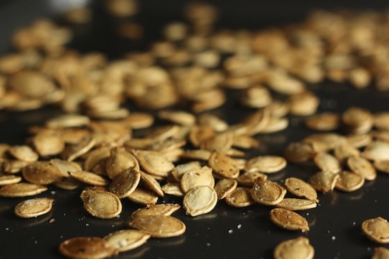 toasted pumpkin seeds sprinkled with sea salt on baking pan