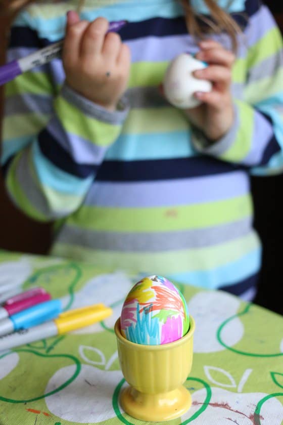 Child colouring egg with sharpies