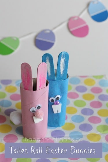 Easter crafts for kids: cardboard roll bunnies in front of a paint chip easter egg garland