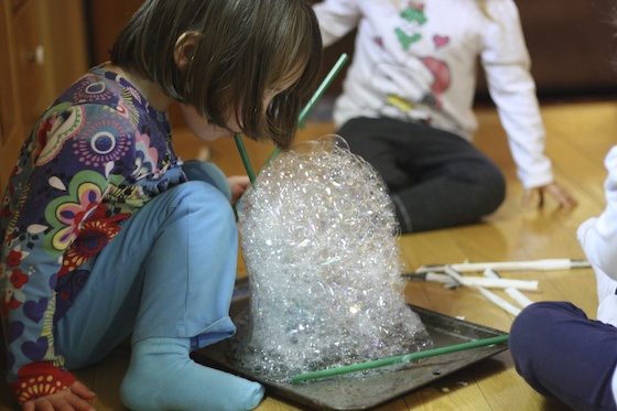 Kids blowing bubbles with a straw