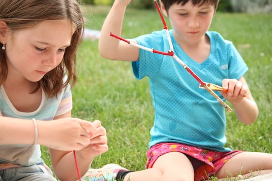 Two girls painting sticks red and white