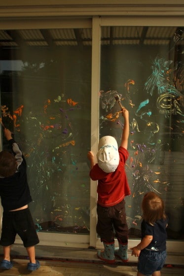 preschoolers painting on patio doors with shaving cream