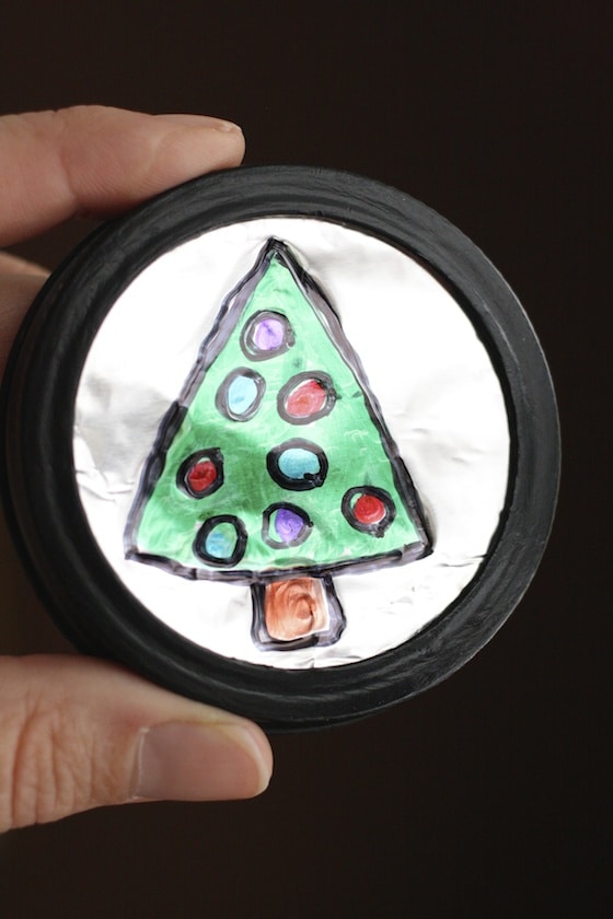 christmas tree drawings on tin foil with Sharpies, in black mason jar lid