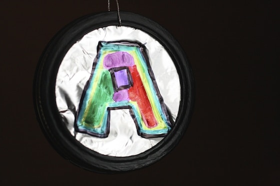 Letter A ornament with foil and sharpies and mason jar lid made by child