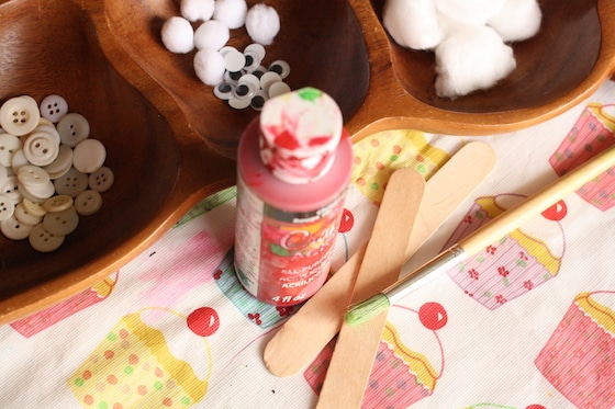 red paint, craft sticks, buttons, cotton balls, google eyes, pom poms