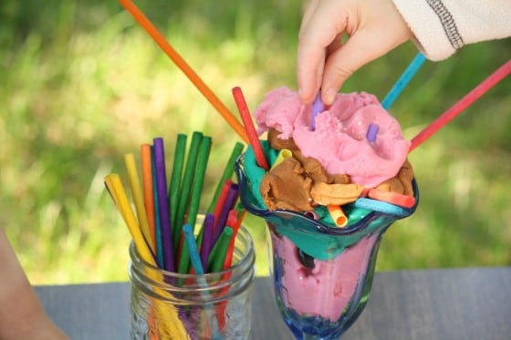 preschooler pressing play dough into ice cream dish