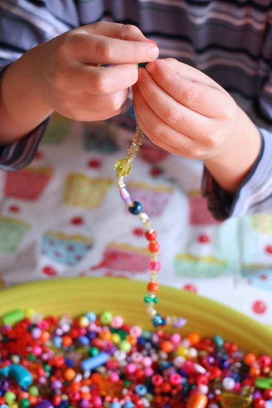 kids threading beads on to pipe cleaners