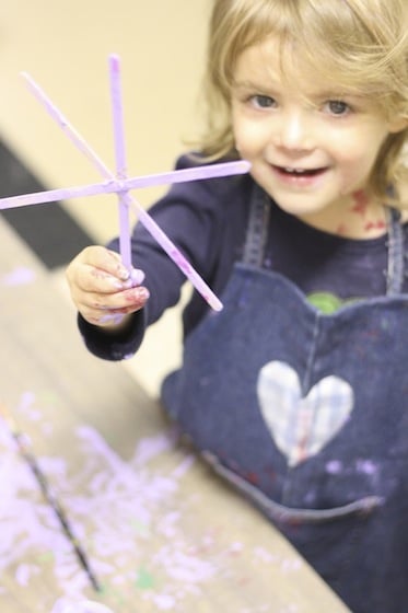 proudly holding up her snowflake ornaments