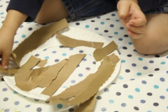 toddlers gluing paper strips to paper plate