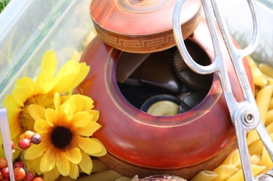 artificial sun flowers, tongs and dried pasta in plastic bin