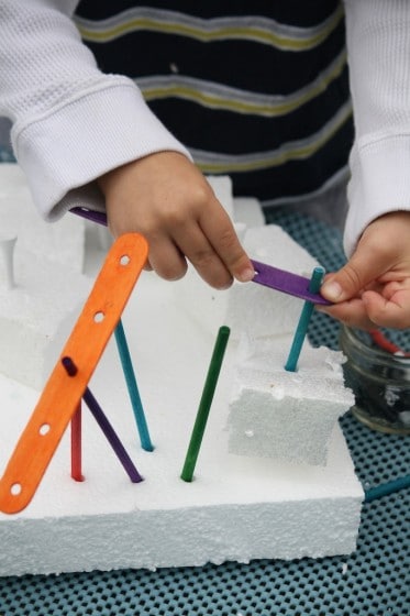 assembling craft sticks in styrofoam