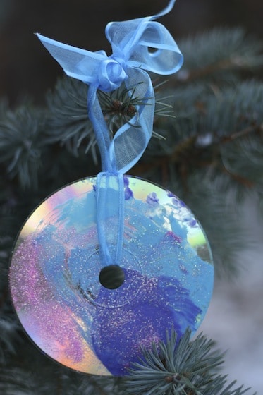 painted and glittered cd christmas ornament hanging in tree