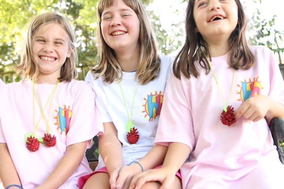 3 girls wearing pinecone apple necklaces