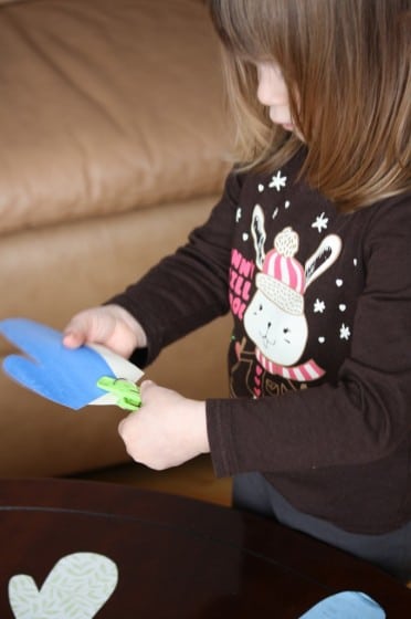 preschooler matching up coloured paper mittens 