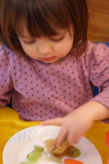 toddler eating french toast in booster 