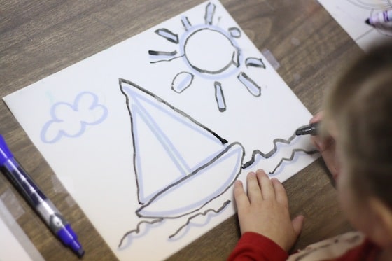 preschooler tracing sailboat on tracing paper