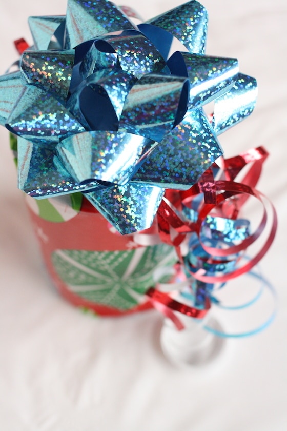 tin can wrapped in wrapping paper with blue bow and ribbon